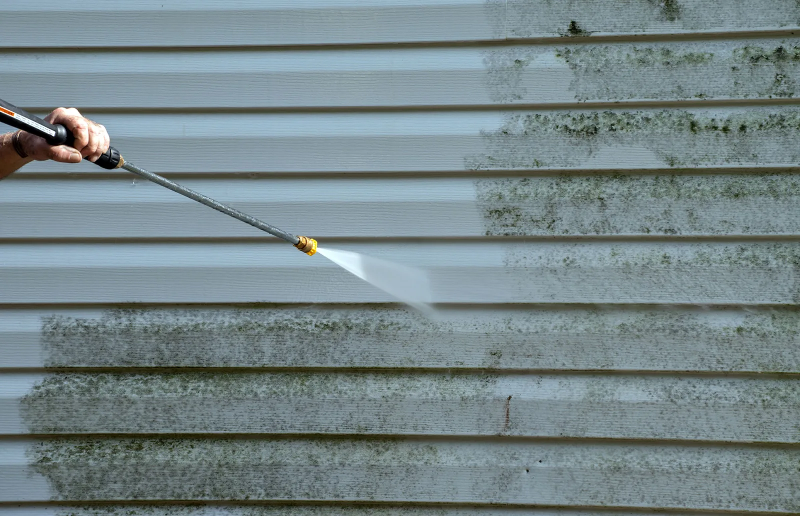 Exterior cleaning removes algae buildup from vinyl siding
